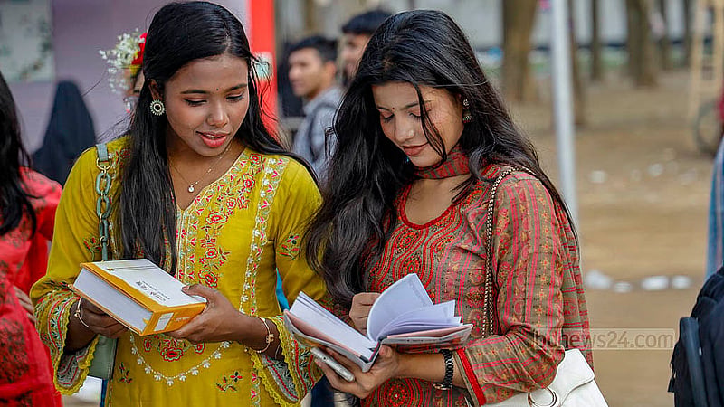 অমর একুশে বইমেলার একটি স্টলে বই দেখছেন দুই তরুণী
