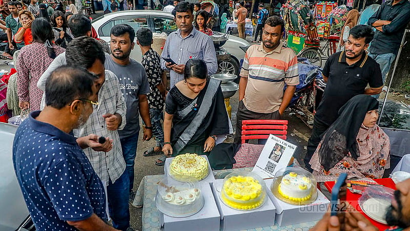 রাজধানীর আগারগাঁও নির্বাচন ভবনের সামনের সড়কজুড়ে বিভিন্ন ধরন ও স্বাদের কেকের পসরা সাজিয়ে বসেছেন নানা বয়সের উদ্যোক্তারা যাদের বেশির ভাগই নারী