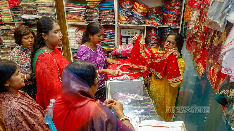 দুর্গাপূজার জন্য শাঁখারিবাজারের একটি দোকানে পোশাক দেখছেন ক্রেতারা