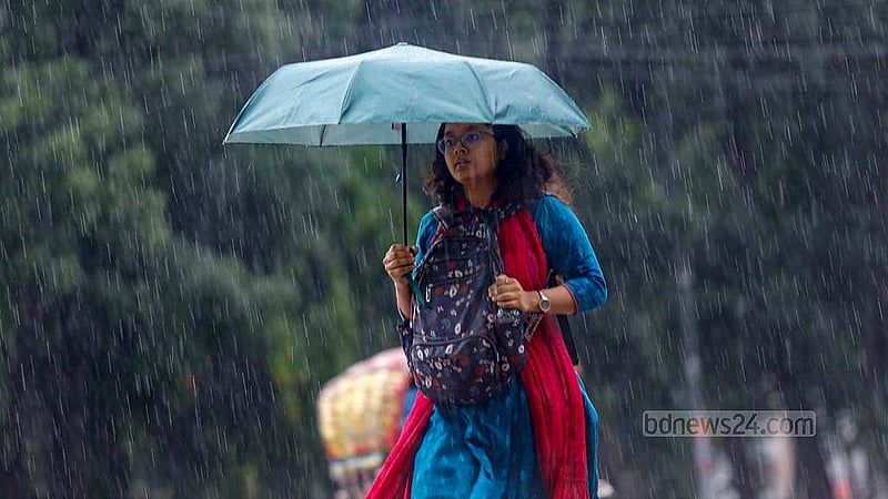 ঢাকা বিশ্ববিদ্যালয় এলাকায় সোমবার দুপুরে মুষলধারে বৃষ্টির মধ্যে ছাতা হাতে এক তরুণী