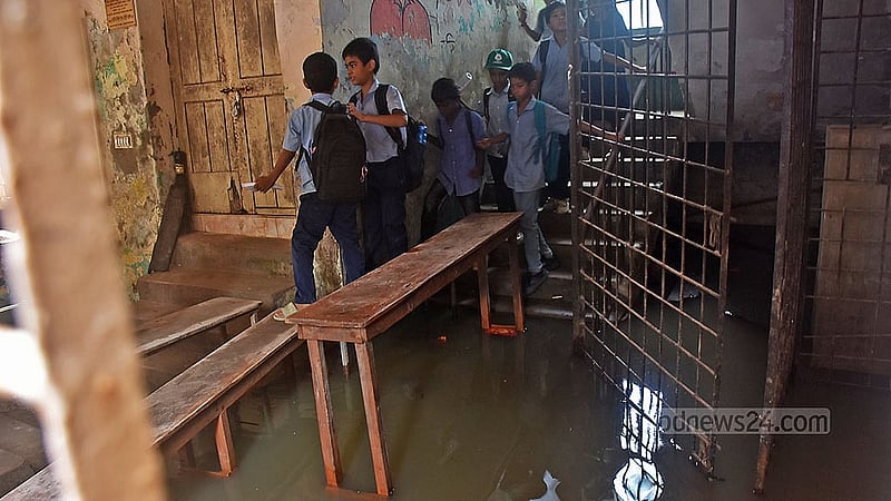 চট্টগ্রাম পশ্চিম বাকলিয়া সরকারি প্রাথমিক বিদ্যালয়ে পানির মধ্যে বেঞ্চ বসিয়ে স্কুল ভবনে প্রবেশ করতে হয় শিক্ষক-শিক্ষার্থীদের