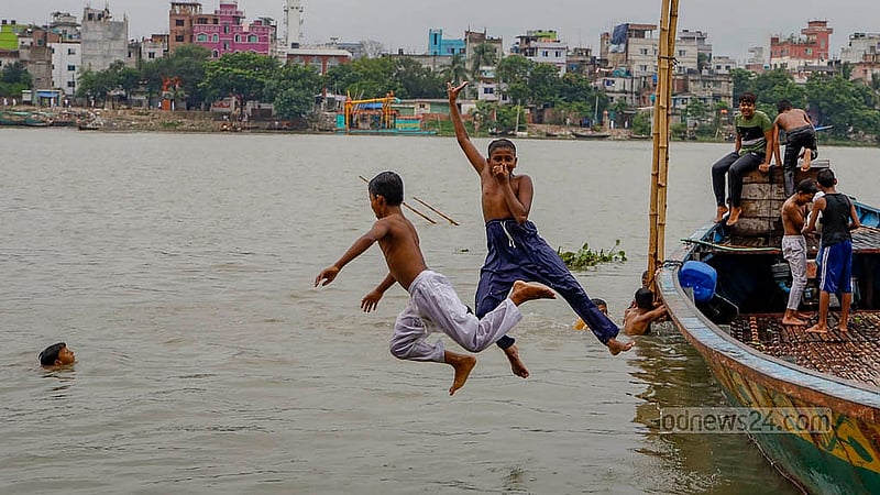 ঢাকার কামরাঙ্গীরচর অংশে ঘাটে নোঙ্গর করা ট্রলার থেকে বুড়িগঙ্গায় লাফাচ্ছে কিশোরদল