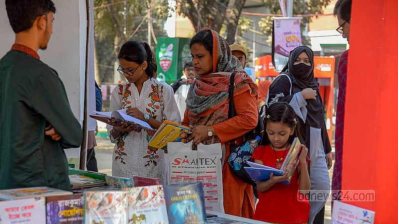 সাপ্তাহিক ছুটির দিন শুক্রবার সকালে বইমেলায় শিশু প্রহরে একটি স্টলে বই দেখছেন শিশুরা।