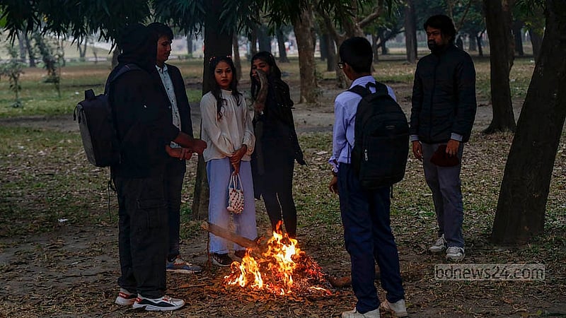 তীব্র শীতে গা গরম করতে ঢাকার জিয়া উদ্যান এলাকায় আগুন পোহাচ্ছেন কয়েকজন