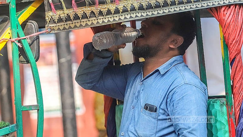 গরমের মধ্যে নিজের কাছে রাখা বোতলের পানিতে গলা ভিজিয়ে নেন এক ইজিবাইক চালক। শনিবার ঢাকা বিশ্ববিদ্যালয় এলাকা থেকে তোলা