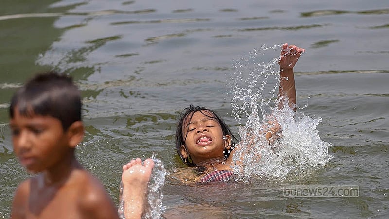 তীব্র গরমে রাজধানীর সোহরাওয়ার্দী উদ্যানের জলাশয়ে পানিতে ভিজতে দেখা যায় শিশুদের
