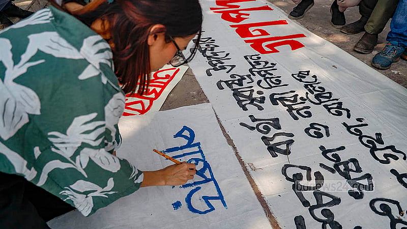 রাজধানীতে কেন্দ্রীয় শহীদ মিনারে ‘ধর্ষণ ও নিপীড়নের বিরুদ্ধে বাংলাদেশ’ ব্যানারে সোমবার দুপুরে পদযাত্রার আগে ব্যানার লিখছেন এক তরুণী