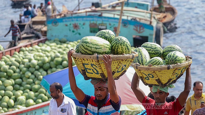পুরান ঢাকার ওয়াইজঘাটে ট্রলার থেকে তরমুজ নামাচ্ছেন শ্রমিকরা