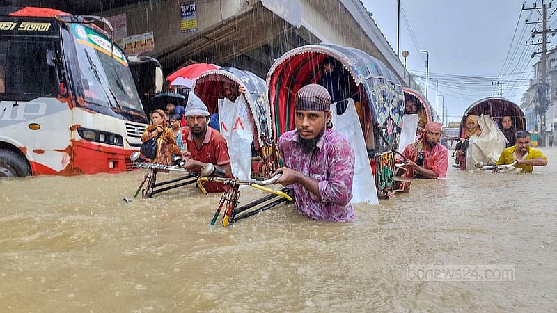 মঙ্গলবার সকালের টানা বৃষ্টিতে জলাবদ্ধতায় খালের পানি উপচে চট্টগ্রাম নগরীর মুরাদপুরে সড়কে কোমড় সমান পানির মধ্যে রিকশা নিয়ে গন্তব্যের উদ্দেশে চালকরা