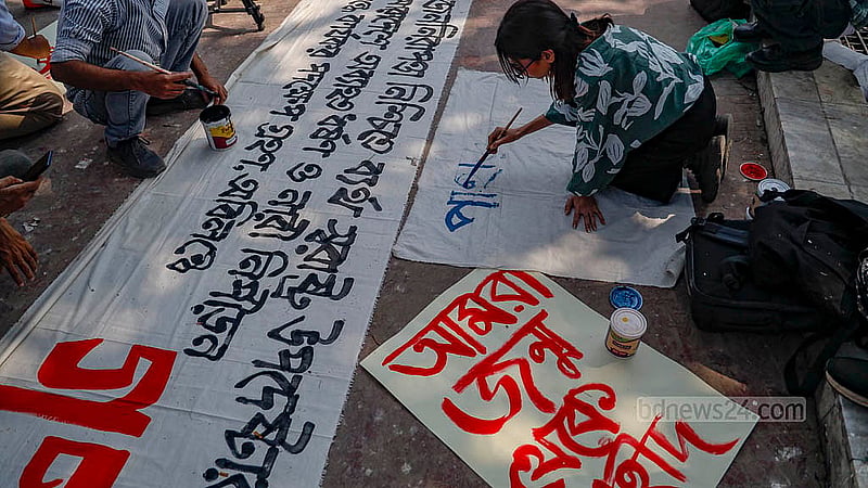 রাজধানীতে কেন্দ্রীয় শহীদ মিনারে ‘ধর্ষণ ও নিপীড়নের বিরুদ্ধে বাংলাদেশ’ ব্যানারে সোমবার দুপুরে পদযাত্রার আগে ব্যানার লিখছেন এক তরুণী