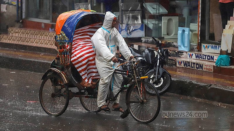 রাজধানীতে মঙ্গলবার বৃষ্টির মধ্যে রেইনকোট পড়ে রিকশা নিয়ে বের হন চালকেরা