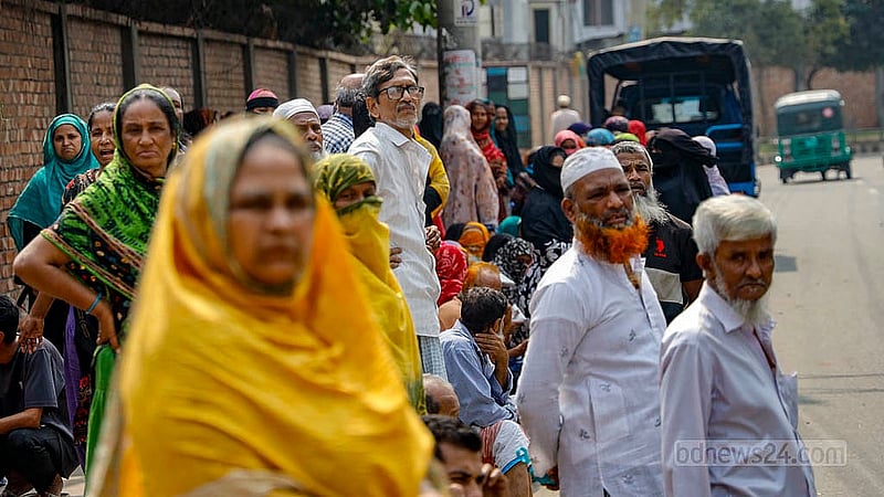 ঢাকার হাতিরঝিলের মধুবাগ অংশে রাস্তায় ঘণ্টার পর ঘণ্টা ধরে বসে আছেন এই নারীরা টিসিবির ট্রাক থেকে পণ্য কিনতে