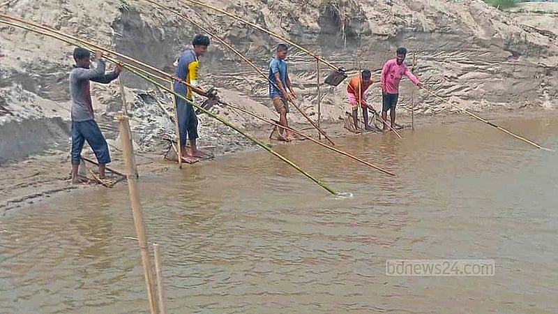 পঞ্চগড়ের তেঁতুলিয়া উপজেলার মহানন্দা ও ডাহুক নদী থেকে পাথর তুলছেন স্থানীয়রা