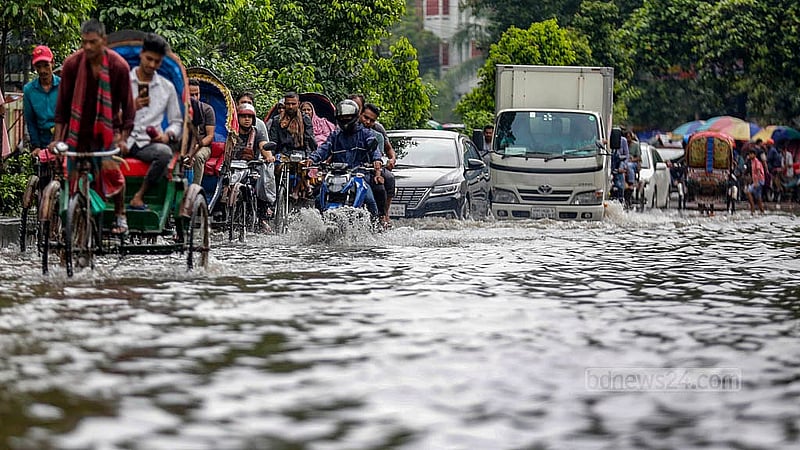 ঢাকার নিউ মার্কেট এলাকায় বৃহস্পতিবার সকালে জলাবদ্ধতা মাড়িয়ে চলে যানবাহন