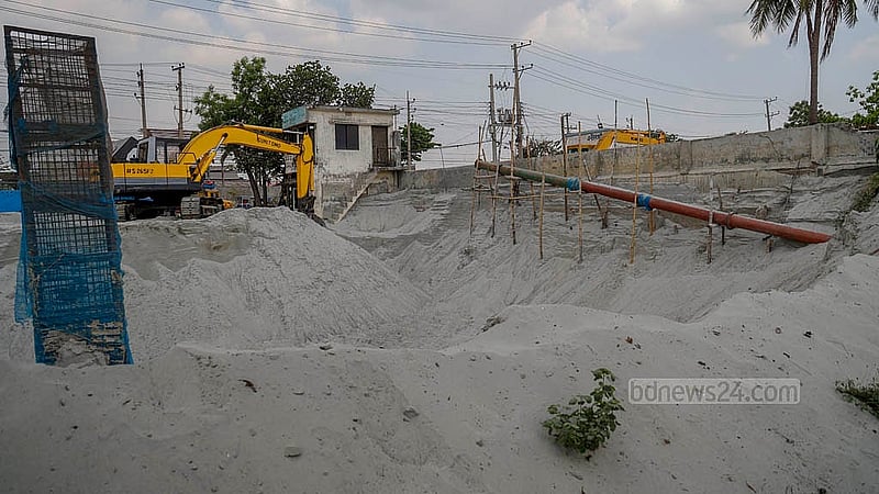 বুড়িগঙ্গা নদীতে নৌযান থেকে ড্রেজার দিয়ে তোলা বালু উন্মুক্তভাবে রাখা হয়ে নদীর সীমানা প্রাচীর ঘেঁষে