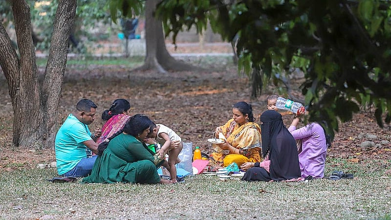 পরিবারের সদস্যদের নিয়ে ঘুরতে আসা দর্শনার্থীরা রমনা পার্কের ঘাসের ওপর চাদর বিছিয়ে আড্ডা দিচ্ছেন