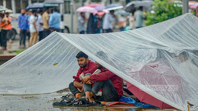 কেন্দ্রীয় শহীদ মিনারের সামনে অবস্থান কর্মসূচি পালন করছেন পল্লী বিদ্যুৎ সমিতির কর্মীরা। বৃষ্টির মধ্যে পলিথিন দিয়ে ছোট ছোট তাবু বানিয়ে তার নিচে অবস্থান করছেন