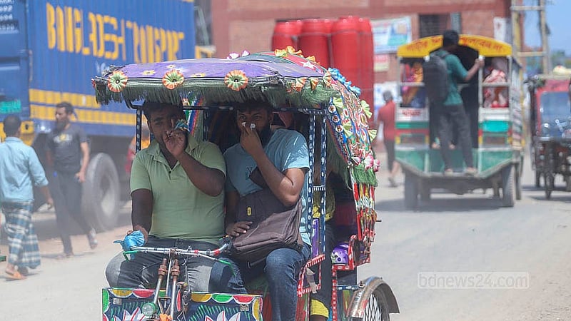 ধুলার কারণে দূষণের তীব্রতায় রাজধানীর বাবুবাজার-গাবতলী বেড়িবাঁধ সড়কে হাত দিয়ে নাক চেপে চলাচল করছে মানুষ