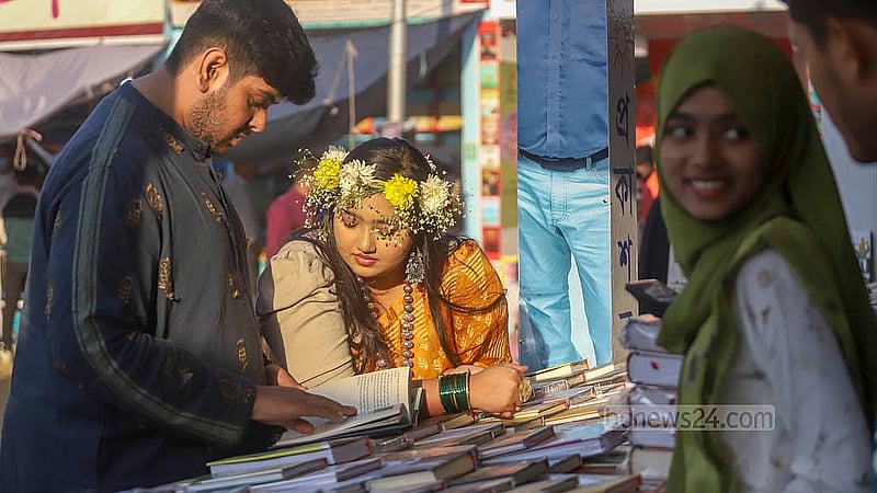ফাগুনের প্রথম দিন আর ভ্যালেন্টাইনস ডের আবহের মধ্যে শুক্রবার একুশে বই মেলায় অনেকের হাতে ছিল ফুল, মাথায় ছিল ফুলের মুকুট