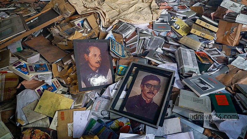 ধানমন্ডির ৩২ নম্বরের জাদুঘরে থাকা লাইব্রেরির একটি কক্ষের মেঝেতে পড়ে থাকা বইয়ের স্তূপের ওপর শেখ মুজিবের পরিবারের ছবি