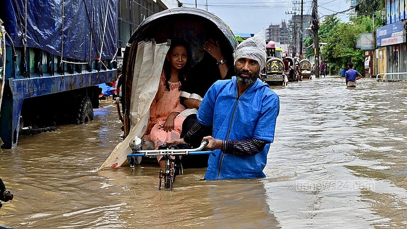 মঙ্গলবার সকালের টানা বৃষ্টিতে জলাবদ্ধতায় খালের পানি উপচে চট্টগ্রাম নগরীর মুরাদপুরে সড়কে কোমড় সমান পানির মধ্যে রিকশা নিয়ে গন্তব্যের উদ্দেশে এক চালক