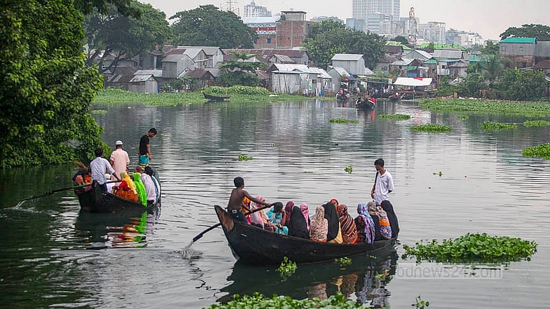ঢাকার কড়াইল বস্তিতে নৌকায় যাতায়াত। বৈঠা হাতে শিশু
