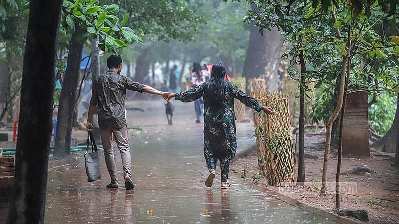 মুষলধারে বৃষ্টিতে মঙ্গলবার রাজধানীর ধানমন্ডি লেকে ভিজতে দেখা যায় অনেককে