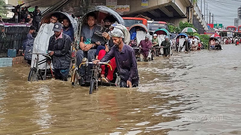 মঙ্গলবার সকালের টানা বৃষ্টিতে জলাবদ্ধতায় খালের পানি উপচে চট্টগ্রাম নগরীর মুরাদপুরে সড়কে কোমড় সমান পানির মধ্যে রিকশা নিয়ে গন্তব্যের উদ্দেশে চালকরা