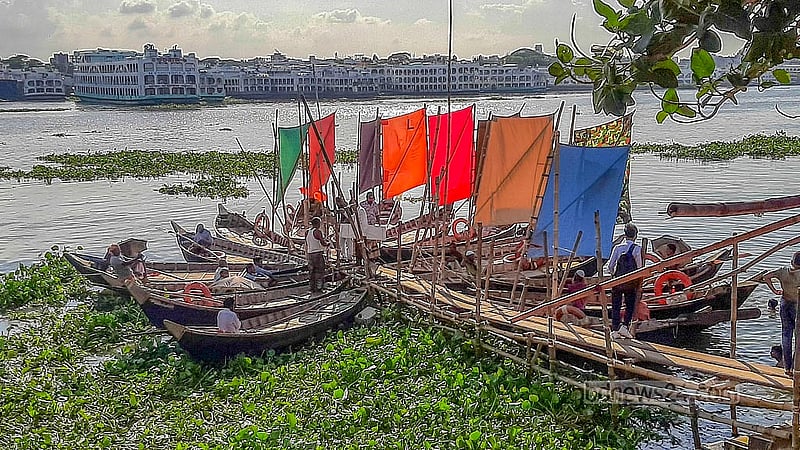 কেরানীগঞ্জে বুড়িগঙ্গার মিল ব্যারাক ঘাটে যাত্রীর অপেক্ষায় খেয়া পারাপারের পালতোলা নৌকা।