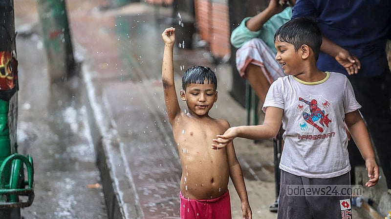 ঢাকার মীরহাজিরবাগ এলাকায় সোমবার দুপুরের বৃষ্টিতে ভিজতে দেখা যায় শিশুদের
