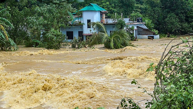 কুমিল্লার বাকশীমূল ইউনিয়নে একটি ঘরের পাশ দিয়ে বয়ে যাচ্ছে বন্যার তীব্র স্রোত