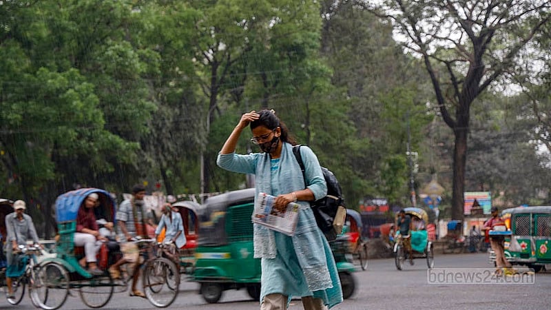 ঢাকা বিশ্ববিদ্যালয় এলাকায় সোমবার বিকালে ছিটেফোঁটা বৃষ্টির মধ্যে মাথা বাঁচানোর চেষ্টায় এক তরুণী