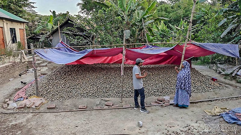 কুমিল্লার বুড়িচংয়ের মিথলমা গ্রামে বাড়ির বাইরে ত্রিপলে ঢেকে রাখা হয়েছে শতশত মণ আলু। এবার উৎপাদন ভালো হলেও দাম না পাওয়ার কথা বলছেন কৃষকরা।