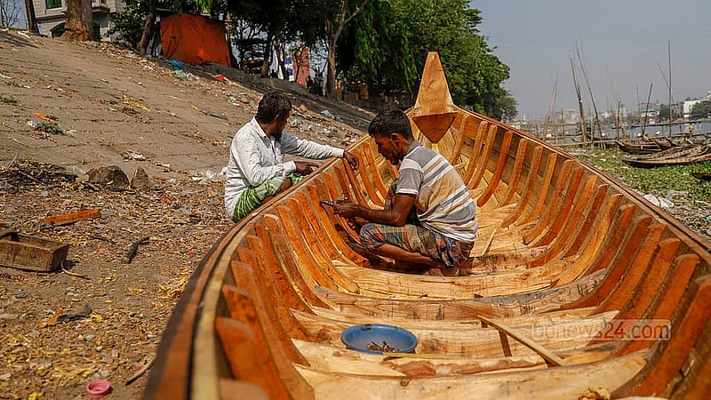 বুড়িগঙ্গা নদীর তীরে ২৫ বছর ধরে নৌকা বানানো কাজ করছেন আমির হোসেন। কাঁঠাল কাঠের নৌকাটি বানাতে তার সময় লাগবে ৭ দিন; কাজ এখন শেষ পর্যায়ে। নৌকা বানানো হয়ে গেলে এটি বিক্রি হবে ২৫ হাজার টাকায়