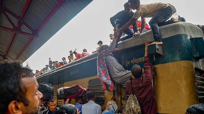 টঙ্গী রেলওয়ে স্টেশনে বৃহস্পতিবার বিকালে ট্রেনের ছাদে এক নারীকে ঠেলে উঠাচ্ছেন তার পরিবারের সদস্যরা