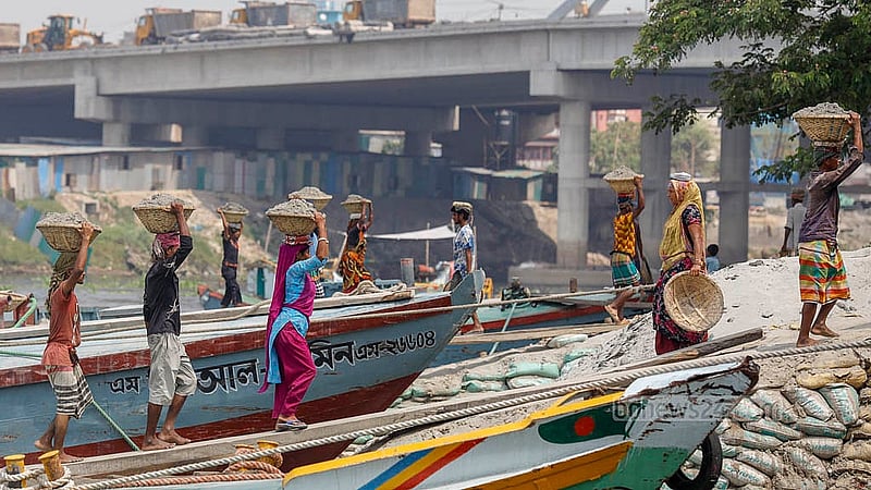 ঢাকার গাবতলীতে বালুর বাল্কহেড থেকে টুকরি ভরে বালু তুলছেন শ্রমিকরা। মে দিবসেও তাদের রুজি-রুটির চিন্তা করতে হয়