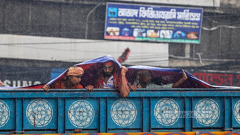 বৃষ্টি নামার পর ট্রাকে থাকা লোকজন মাথার ওপর ত্রিপল বিছিয়ে নেন। বৃহস্পতিবার রাজধানীর দোলাইরপাড় এলাকা থেকে তোলা