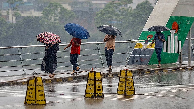 হাতিরঝিল এলাকায় রোববার দুপুরে বৃষ্টির মধ্যে ছাতা হাতে গন্তব্যের পথে অনেকে