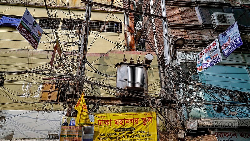 পুরান ঢাকার লালবাগের শহীদ নগর এলাকায় বিদ্যুতের খুঁটিতে থাকা ট্রান্সফরমার চারপাশ ছেয়ে গেছে তারের জঞ্জালে