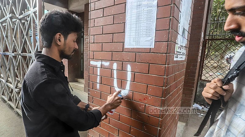 তিতুমীর কলেজের দেয়ালে অমোচনীয় কালি দিয়ে ‘তিতুমীর বিশ্ববিদ্যালয়’ এর সংক্ষিপ্ত রূপ হিসেবে ‘টি ইউ’ লিখছেন এক শিক্ষার্থী