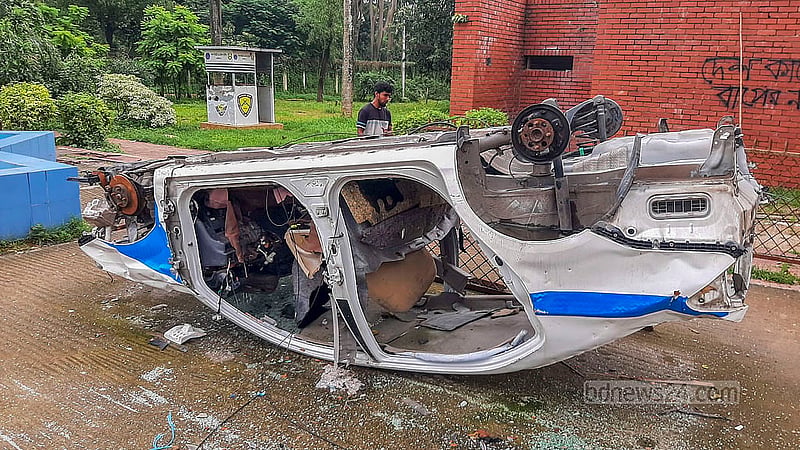 শেরেবাংলা নগরে গণভবনের প্রবেশমুখে পুলিশের একটি গাড়ির কঙ্কাল উল্টে আছে।