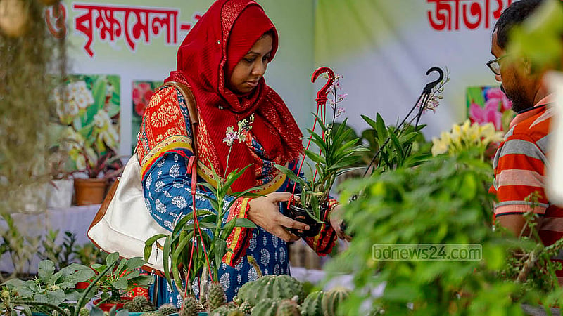 ঢাকার শেরে বাংলা নগরে রোববার জাতীয় বৃক্ষ মেলার একটি স্টলে গাছ দেখছেন এক নারী