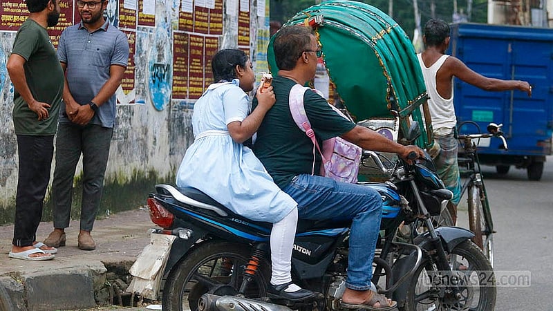 বাবা-সন্তান কারও মাথায়ই নেই হেলমেট। রাজধানীর পলাশীর মোড়ে দেখা গেল তাদেরকে