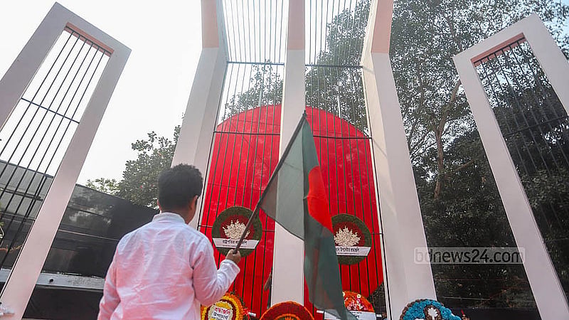 আন্তর্জাতিক মাতৃভাষা দিবসে কেন্দ্রীয় শহীদ মিনারের  সামনে জাতীয় পতাকা হাতে দাঁড়িয়ে এক শিশু