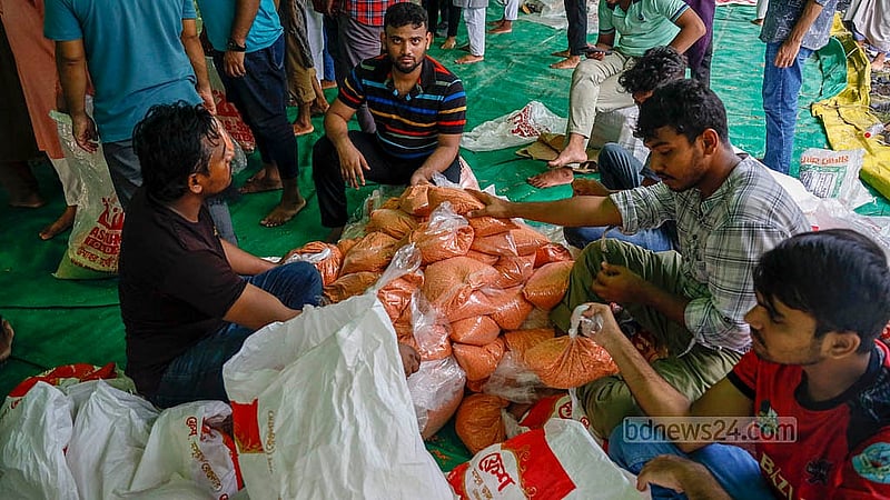 ঢাকার বাড্ডার সাতারকুলে আস সুন্নাহ ফাউন্ডেশনের আওতায় স্বেচ্ছাসেবীরা দলবদ্ধ হয়ে ত্রাণ প্রস্তুতের কাজ করছেন; নির্দিষ্ট পরিমাণ চাল-ডাল-তেল তারা প্যাকেটে সাজাচ্ছেন