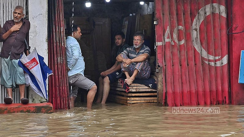 মঙ্গলবার সকাল থেকে ৬ ঘণ্টার বৃষ্টিতে চট্টগ্রাম নগরীর মুরাদপুর এলাকায় একটি দোকানের ভেতরে পানি ঢুকে যাওয়ায় অলস বসে আছেন কর্মচারীরা