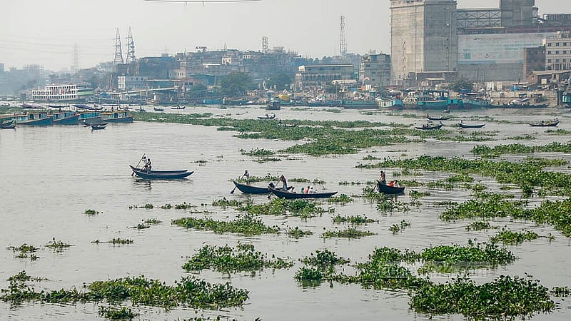 বুড়িগঙ্গায় কচুরিপানার মধ্যে দিয়ে যাত্রী নিয়ে চলাচল করছে খেয়া নৌকা