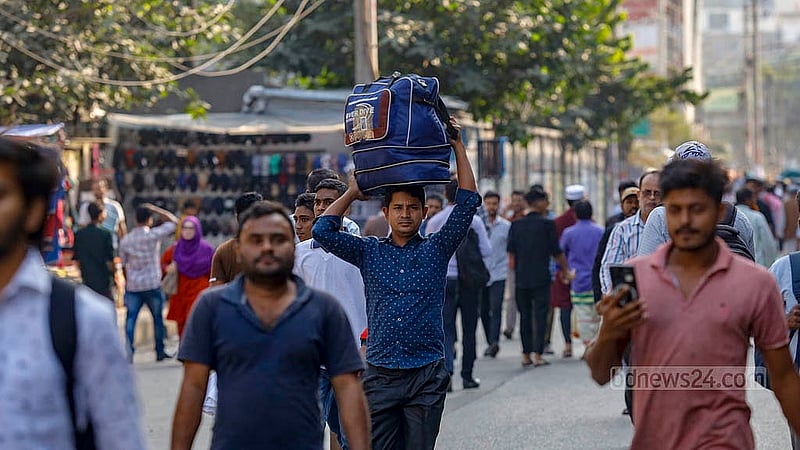 অবরোধের কারণে যান চলাচল বন্ধ; মাথায় ব্যাগ তুলে পায়ে হেঁটে গন্তব্যের পথে এক ব্যক্তি