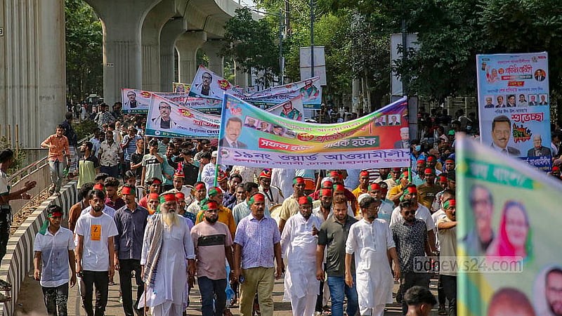 ঢাকা বিশ্ববিদ্যালয় এলাকায় রোববার দুপুরে দলের ব্যানার হাতে নেতা কর্মীরা। সোহরাওয়ার্দী উদ্যানে আওয়ামী লীগের ৭৫তম প্রতিষ্ঠাবার্ষিকীর সভায় যোগ দিতে এসেছেন তারা