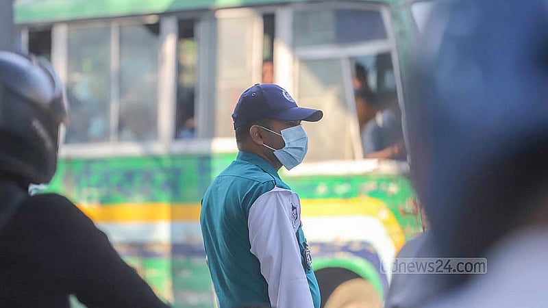 রাজধানীর পল্টনে ধুলা থেকে রক্ষায় মাস্ক পরে দায়িত্ব পালন করছেন ট্রাফিকের এক পুলিশ সদস্য